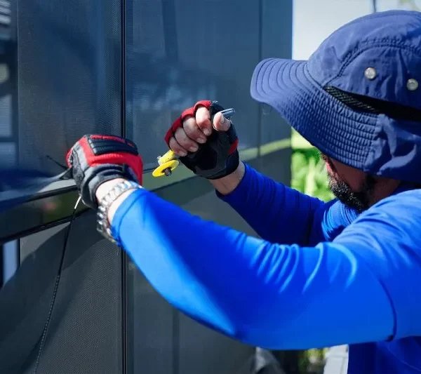 Lanai screen repair in Kissimmee, FL with technician rescreening enclosure panel