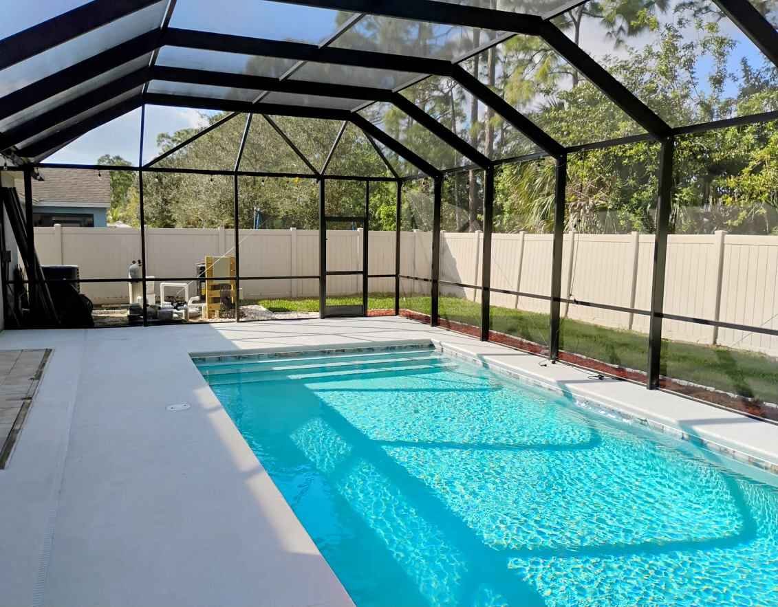 Pool screen enclosure installation in Kissimmee, FL covering residential backyard swimming pool